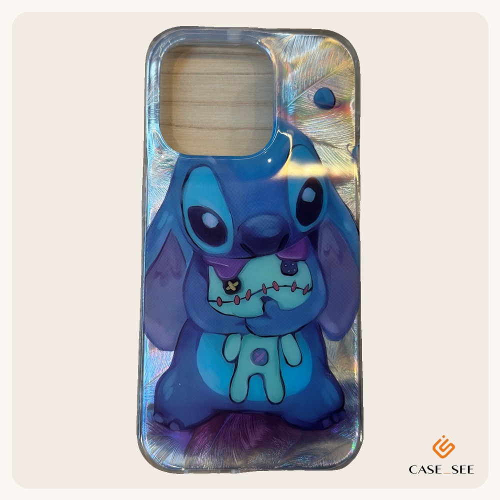 Capa transparente com o Stitch abraçando a boneca Scrump sobre um fundo holográfico de penas que muda de cor conforme a luz.